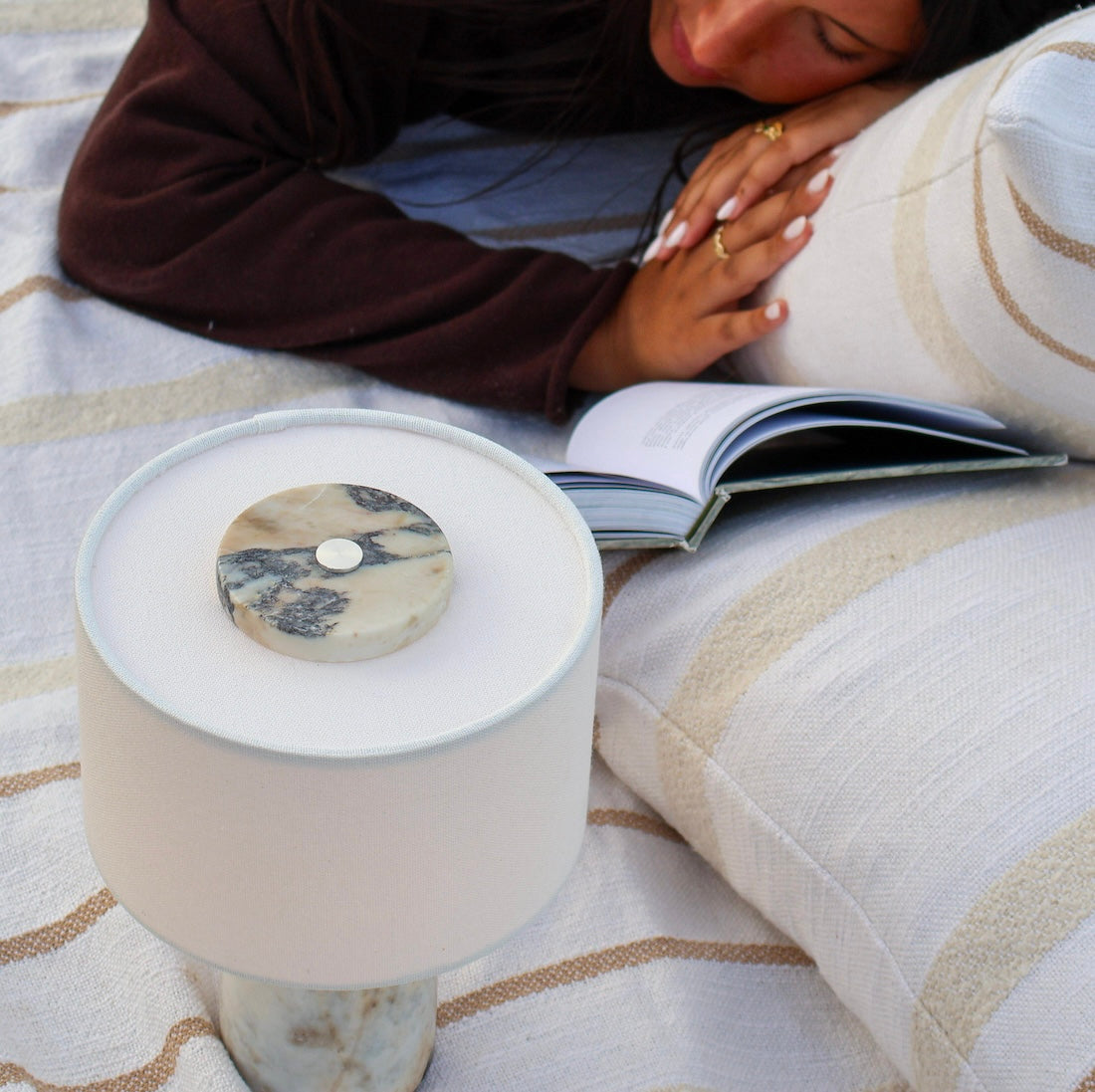 Calacatta Viola marble table lamp styled outside on blanket with warm ambient glow