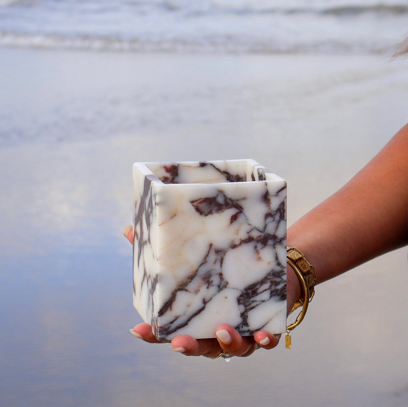 Calacatta Viola marble square vessel sculptural marble jar by Lokah & Co held by woman