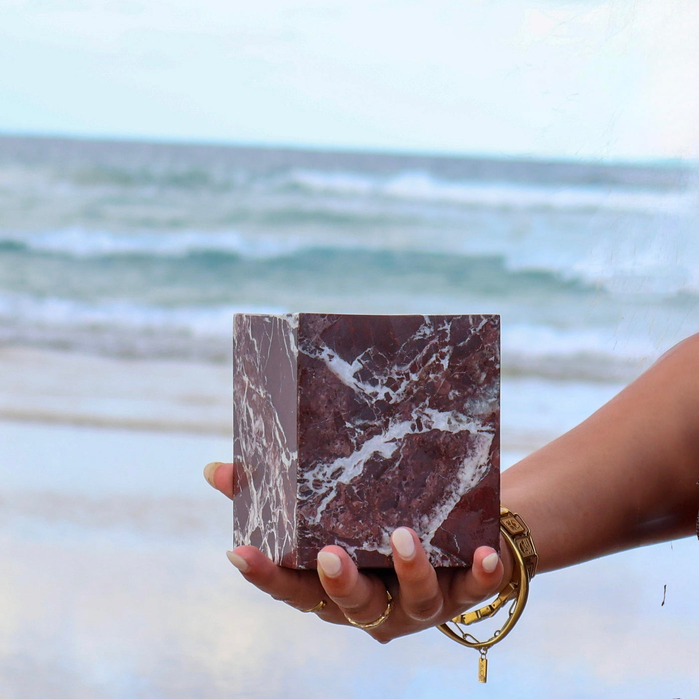 Rosso Levanto marble vessel showing natural red stone veining held by woman