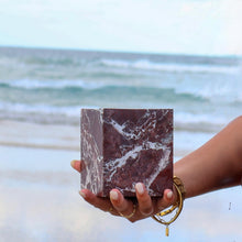 Rosso Levanto marble vessel showing natural red stone veining held by woman