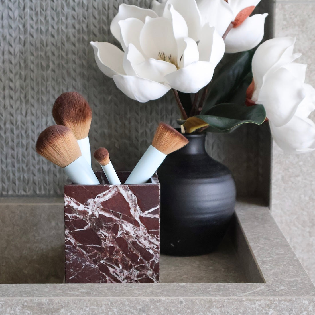 Rosso Levanto marble vessel styled on bathroom vanity as make-up canister