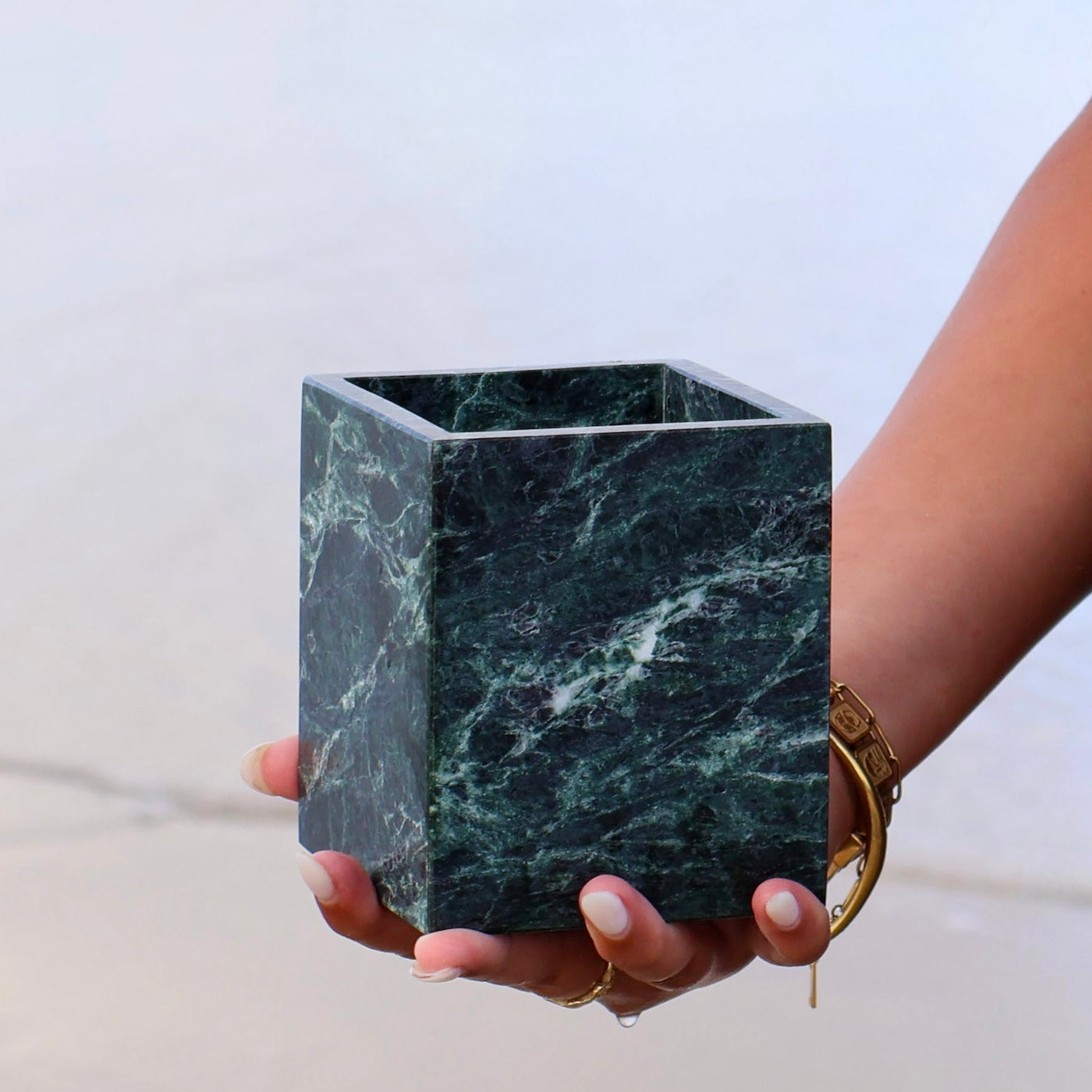 Verde Alpi marble square vessel sculptural green marble jar by Lokah & Co held by a woman