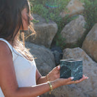 Verde Alpi marble vessel being held by woman showing natural green stone veining